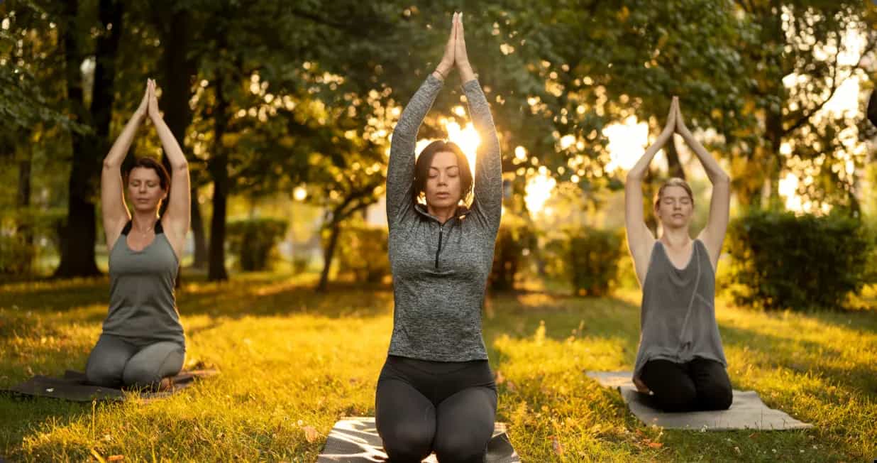 Women meditating together in a park
